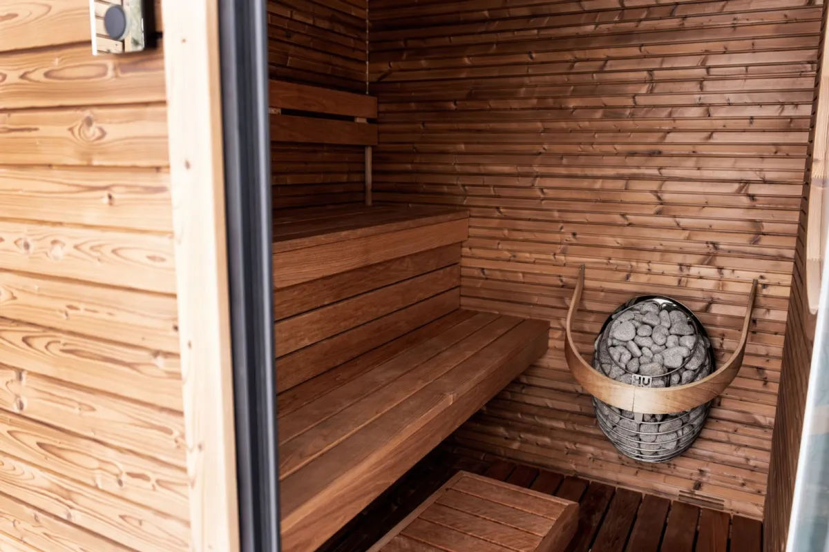 A wood-lined home sauna interior with an electric heater